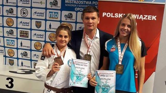 zawodniczki z medalami i trenerem