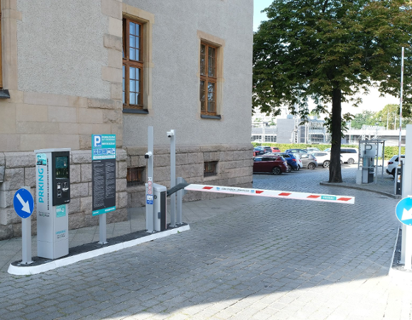UAM otwiera parking w centrum w tle budynku i aut zdjęcie szlabanu prowadzacego na parking