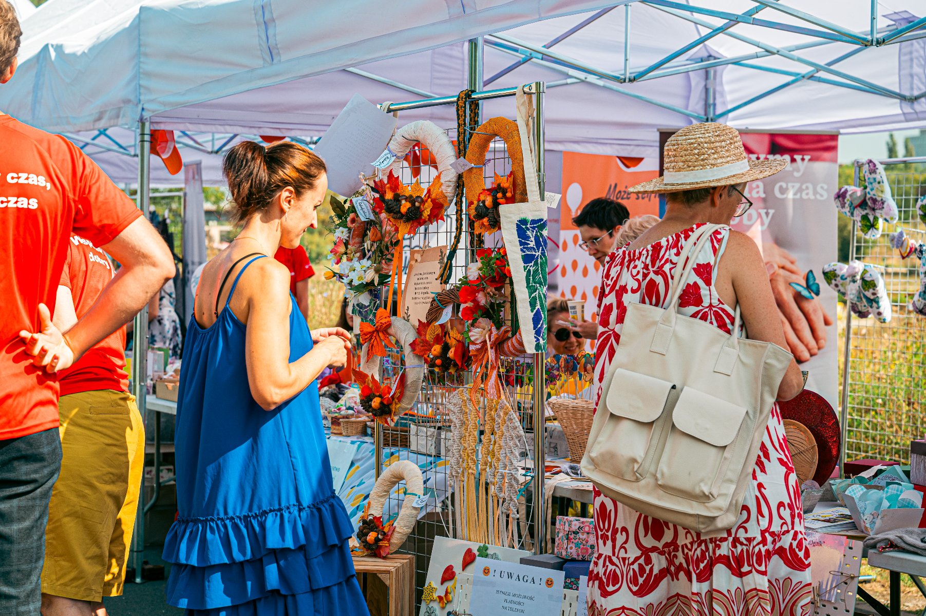 W tym roku odbędzie się już piąta edycja Poznańskiego Targu Dobra Na zdjęciu kobieta przypatrująca się stoisku, ma koszulkę z napisem: wspólny czas - dobry czas