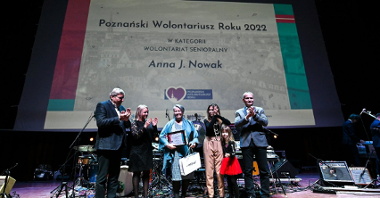 Galeria zdjęć przedstawia osoby stojące na scenie podczas wręczania nagród w ramach konkursu Poznański Wolontariusz Roku 2022.