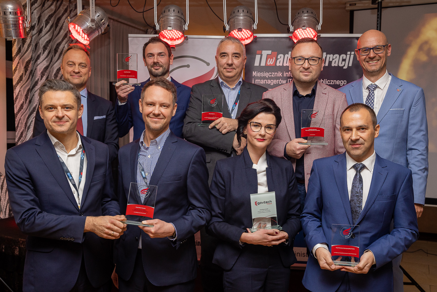 The photo shows a group of people holding the Wings of IT in Administration award statuettes in their hands. - grafika artykułu