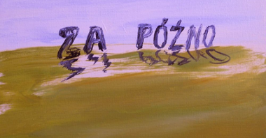 One of the works from the exhibition.The caption "Za późno" on a green field, blue sky behind it.
