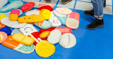 Photo of artist's works - pieces of a soft, colourful cloth in a shape of pills.