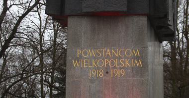 Photo of the monument to the Greater Poland Insurgents. A burning grave candle in front of the monument, soldiers next to it.