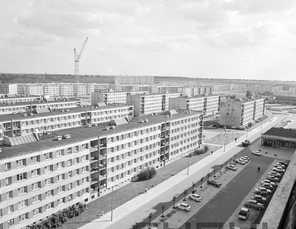 Osiedle Piastowskie, 1974 r., fot. S. Wiktor Czarno-białe zdjęcie bloków mieszkalnych stojących równolegle do siebie. Przed blokami parking samochodowy, chodnik i trawnik.