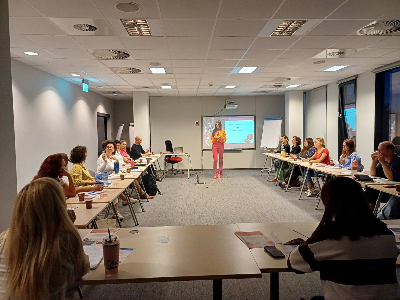 Szkolenie pt. Jak wykorzystać swoją kreatywność do budowania autentycznej marki osobistej, by przyciągać społeczność, która ufa i kupuje Grafika przedstawiająca zdjęcie ze szkolenia. Na zdjęciu są uczestnicy szkolenia stacjonarnego, którzy siedzą w sali szkoleniowej.