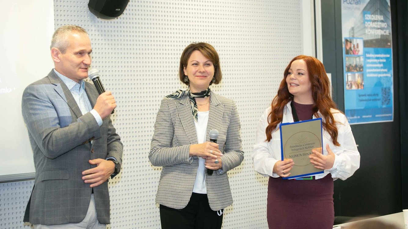 Zastępca Prezydenta Miasta Poznania Jędrzej Solarski przemawia przez mikrofon, obok Dyrektor Wydziału Działalności Gospodarczej i Rolnictwa Joanna Jajus oraz przedstawicielka fundacji Nejmowirna. W tle na drzwiach wisi plakat promujący Poznań Biznes Partner. Wszyscy stoją i otwierają wydarzenie Dzni Przedsiębiorczości Poznań 2024.