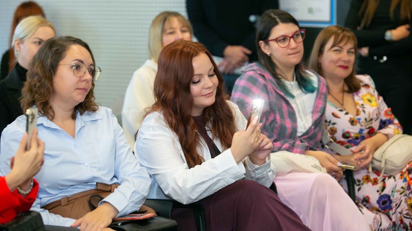 Kilka osób z widowni słucha i robi zdjęcia telefonami podczas konferencji "Twój czas na zmianę: od inspiracji do działania". Wydarzenie odbywa się w Plus Jeden.