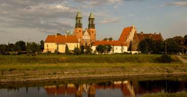 Zdjęcie przedstawia widok na Wartę i Ostrów Tumski, na którym wdać wieże Poznańskiej Katedry.