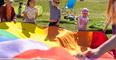 Na zdjęciu dzieci bawiące się kolorową chustą/ fot. MTP