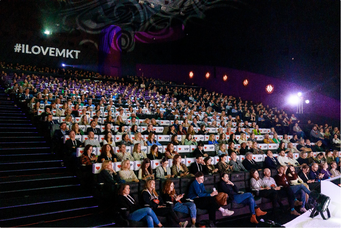 I Love Marketing & Technology to wydarzenie marketingowo-technologiczne organizowane przez agencję Sprawny Marketing/ fot. ILM&T Sala konferencyjna pełna ludzi, w tle napis: "I Love Mkt".