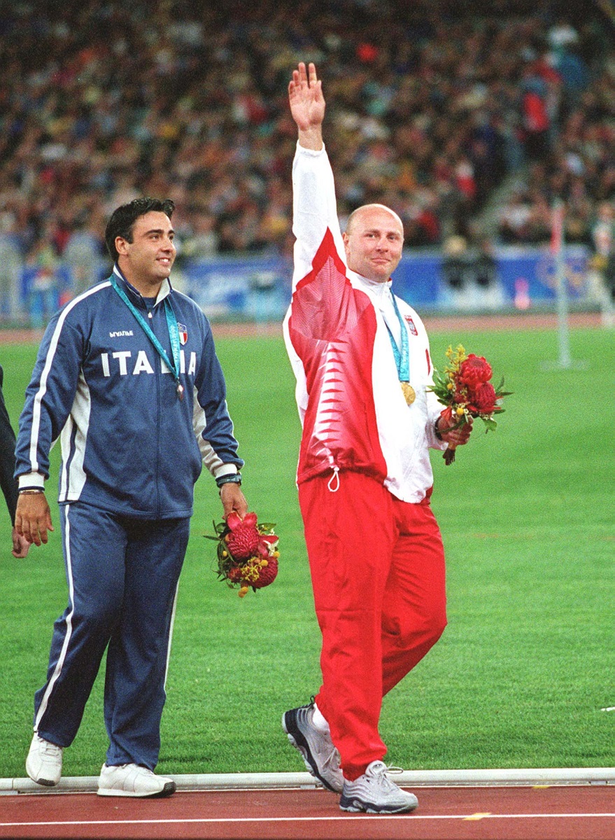 Szymon Ziółkowski, zwycięzca olimpijskiego konkursu rzutu młotem na igrzyskach olimpijskich w Sydney w 2000 r., tuż po ceremonii wręczenia medali, fot. ze zb. Polskiej Agencji Prasowej - grafika artykułu