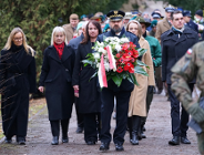 Członkowie delegacji składają kwiaty.