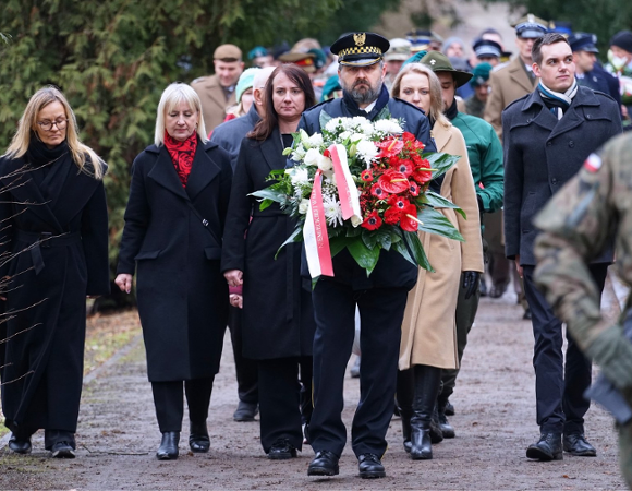 Członkowie delegacji składają kwiaty.