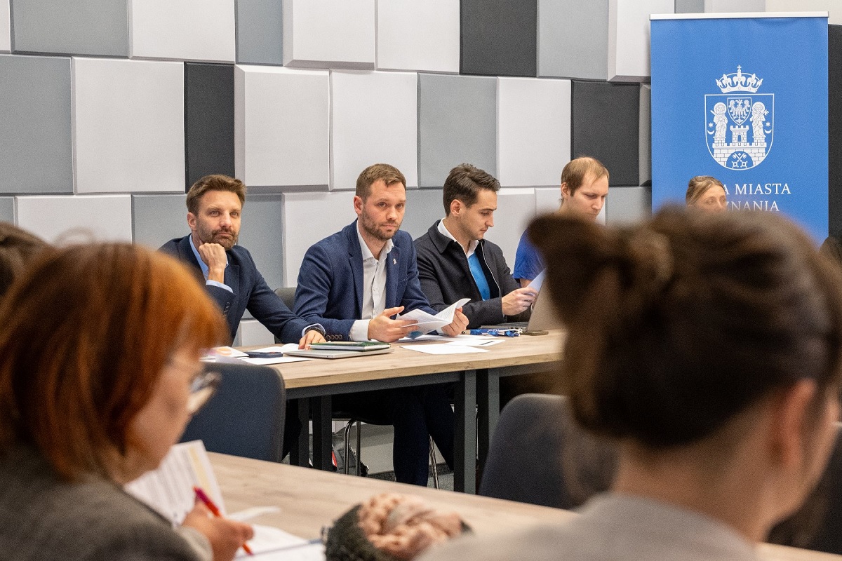 kilkoro osób w sali przy stole konferencyjnym - grafika artykułu