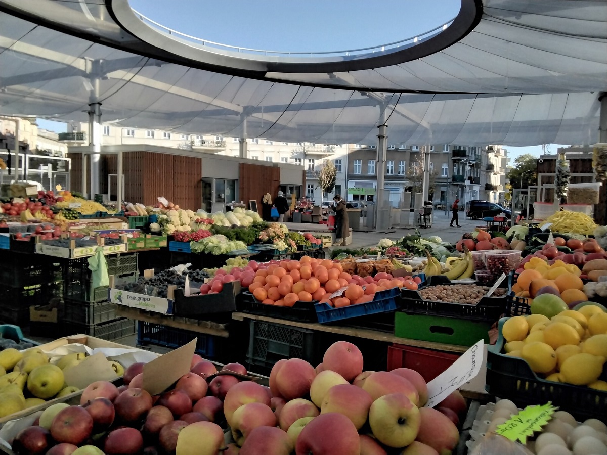 targowisko na ryneczku, zadaszone, widać stragany z owocami i warzywami - grafika artykułu