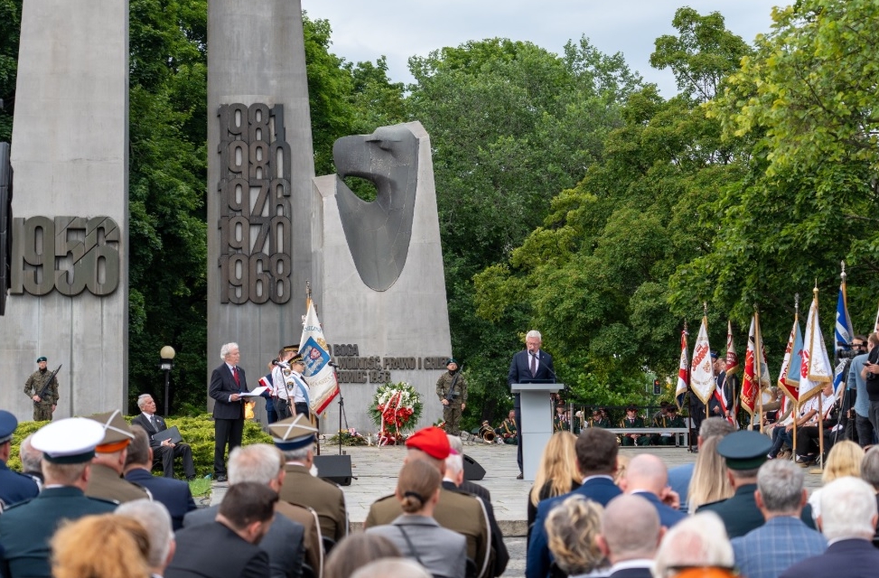 uroczystości przed pomnikiem Poznańskiego Czerwca 1956, uczestnicy stoją ze sztandarami, jedna osoba przemawia - grafika artykułu
