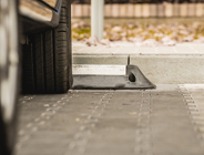 samochód na parkingu, widoczne tylko opony i dolna część auta