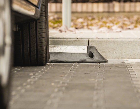 samochód na parkingu, widoczne tylko opony i dolna część auta