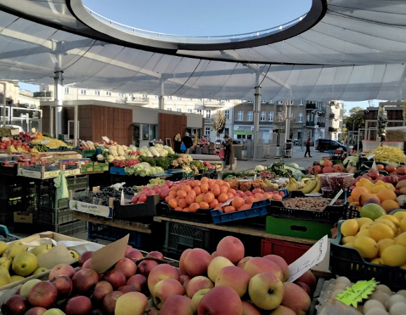 targowisko na ryneczku, zadaszone, widać stragany z owocami i warzywami