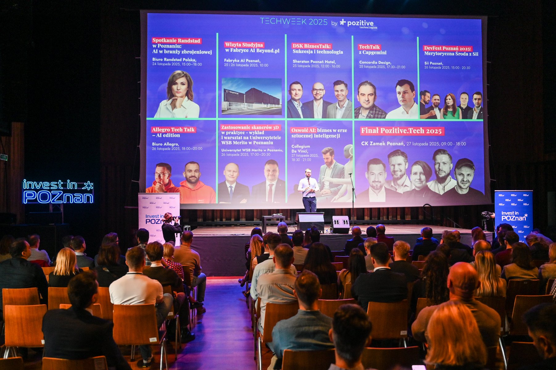 w dużej sali konferencyjnej wiele osób siedzi na krzesłach ustawionych w rzędach, sala jest przyciemniona, na dużym ekranie wyświetlana jest prezentacja