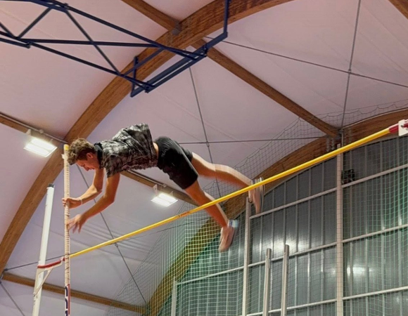 zawodnik skoku o tyczne podczas oddwania skoku, na zdjęciu znajduje się już nad drążkiem