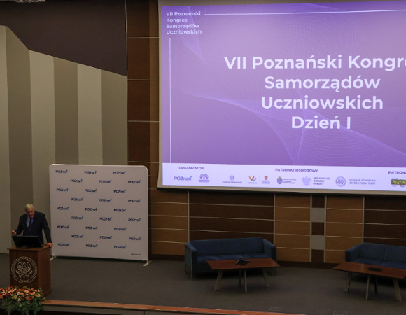 Zdjęcie przedstawia przemawiającego w auli przewodniczącego rady miasta.