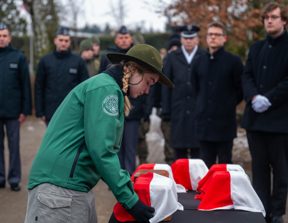 Zdjęcie z uroczystości. Harcerka trzyma urnę.