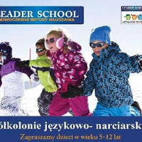 Baner: 4 dzieci w kolorowych kombinezonach narciarskich biegnie po śniegu.