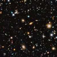 Zdjęcie przedstawia widok kosmosu z teleskopu Hubble'a. Różnobarwne gwiazdy świecą na ciemnym tle.