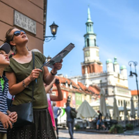 MAtka z synę patrzą na fasadę budynku Muzeum Archeologicznego. W tle Ratusz.