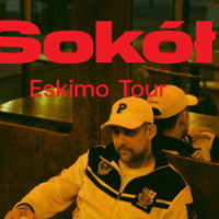 Raper w czapce i bluzie sportowej siedzi w barze, za nim lustro. Czerwony napis Sokół Eskimo Tour.