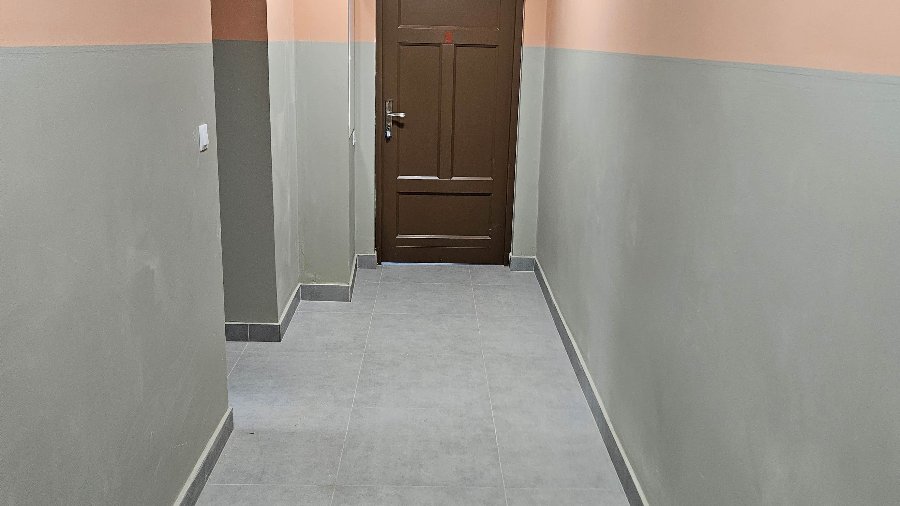 Zdjęcie przedstawia korytarz i drzwi.