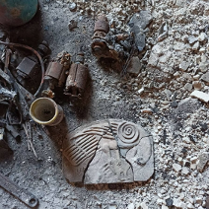 Picture of various objects, including an empty mug, a damaged tile and debris.