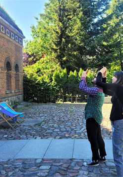 Dwie osoby przed budynkiem Śluzy robią zdjęcie.