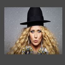 Zdjęcia na któym na tle przypominającym rozgwieżdżone niebo znajduje się Katarzyna Nosowska w czarnym kapeluszu.