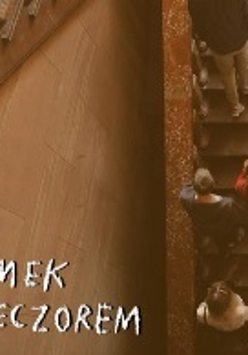 Zdjęcie przedstawia osoby zwiedzające Zamek, które wchodzą na pierwsze piętro po Schodach Paradnych. Na dole napisano białym odręcznymi literami: ZAMEK WIECZOREM.