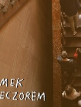 Zdjęcie przedstawia osoby zwiedzające Zamek, które wchodzą na pierwsze piętro po Schodach Paradnych. Na dole napisano białym odręcznymi literami: ZAMEK WIECZOREM.