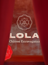 Zza czerwonej kurtyny wyłania się logo klubu i napis "LOLA Chinese Extravaganza".