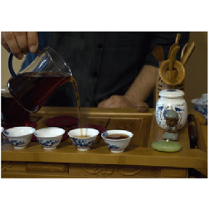 Mężczyzna nalewający herbatę do filiżanek