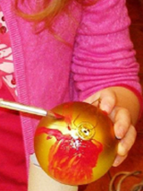 dziewczynka maluje bombkę.