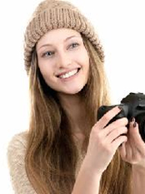 Foto: dziewczyna w czapce z aparatem fotograficznym.