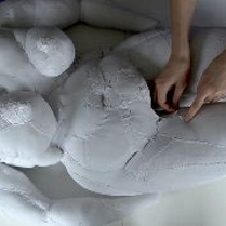 Szyta rzeźba z materiału przedstawia sylwetkę kobiety.