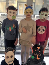 % dzieci w maskach z papieru. 3 stoi, 2 kuca.