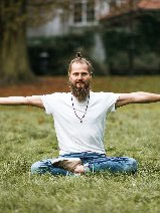 Jogin ćwiczy na trawie.