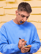 Młody artysta z pisakiem w ręku w trakcie pisania nim.