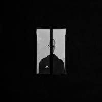 Jedna z prac Piotra Zugaja. Widać zdjęcie człowieka, którego widok jest załamany przez wewnętrzne ramy okienne.