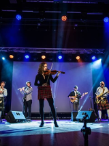 Zdjęcie członków zespołu podczass występu na scenie.