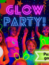 Grupa dzieci z plamami farby święcącej w ciemności. Obok nich opiekunowie w przebraniach Koziołka Matołka i Cliforda czerwonego psa/