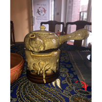 Imbryk do herbaty na podgrzewaczu na stole